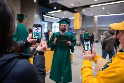 A student's family takes a picture during commencement